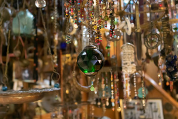 Fototapeta na wymiar Round pendant with green crystal on it close up. The photo was taken in front of the store.