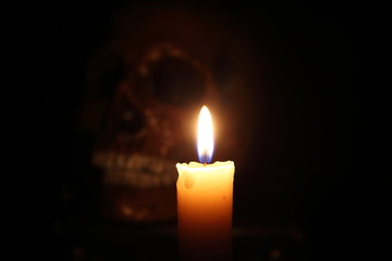 Skull and candle. Black magic. Focus on candle