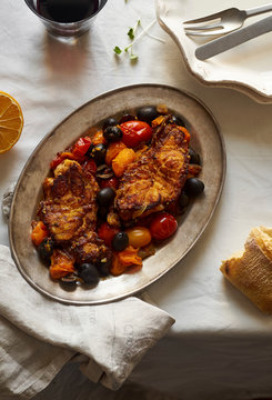 Roasted white fish with cherry tomatoes, lemon rind and olives