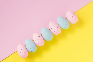 Easter pastel eggs on a yellow-pink background. Flat lay.