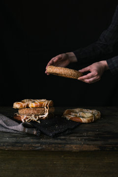 A Women's Hands Taking Bagel on a Black Background