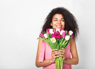 Young african woman with flowers on white background. Women's day concept