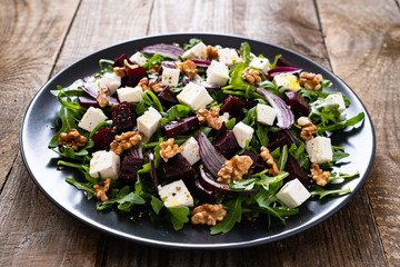  Beetroot salad with goat cheese on wooden background