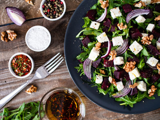  Beetroot salad with goat cheese on wooden background