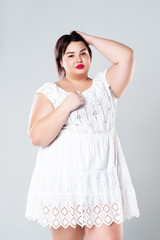 Plus size fashion model in casual clothes, fat woman on gray background