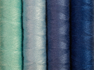 Set of multi-hue thread bobbins.