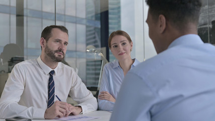 The Rear Back View of Man having Talk on Document with Business People