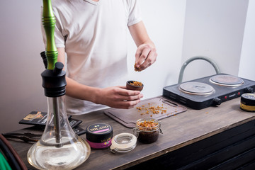 Cooking hookah in the bar. Cutting tobacco into a bowl. Restaurant