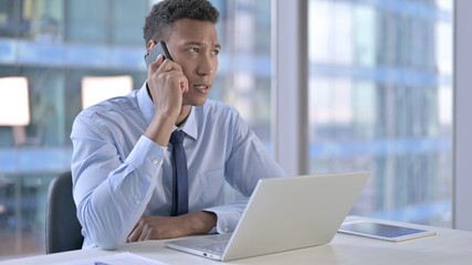 The African Businessman Talking on Smartphone in Office
