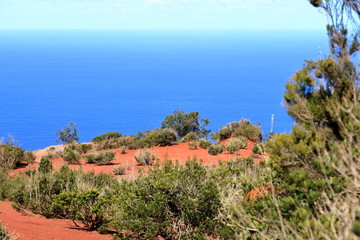 Colorful red earth and sand hills of volcanic origin above 
