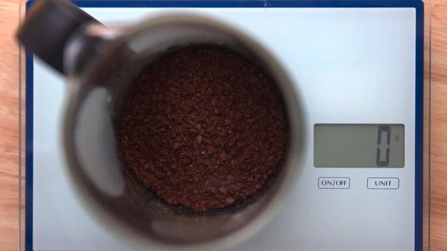 Top down close-up: Spooning coffee into French Press on a food scale