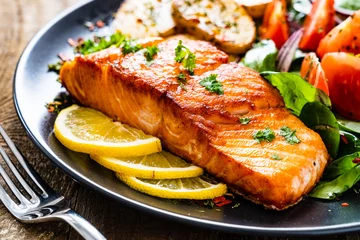 Fotobehang Kruidenier Fried salmon steak with potatoes and vegetables on wooden table  © Jacek Chabraszewski