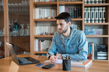 Young male studying for university at home via online lessons during the coronavirus quarantine....