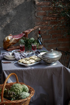 Mediterranian Tablecloth with whole ham jamon serrano leg, baked artichokes and red wine