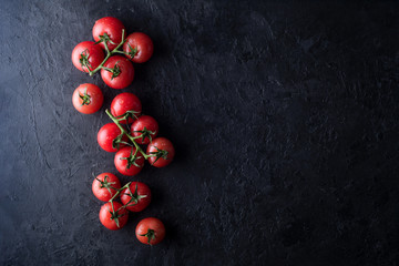 Fototapeta na wymiar Red tomatoes on a dark concrete background. Top view. Fresh juicy tomatoes.