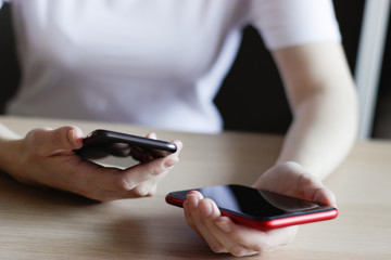 young woman with two smartphones in hand