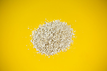 Oatmeal in a pile, yellow background