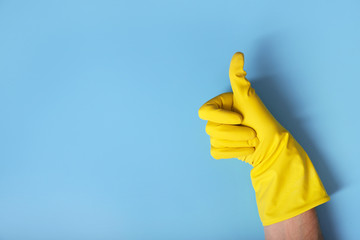 Hands in gloves on blue background. Thumbs up