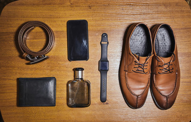 different accessories of a businessman for creating a style of a people lie on a wooden background