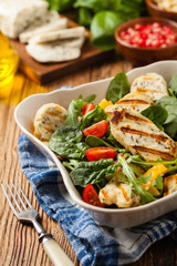 Traditional Greek salad with grilled Halloumi cheese with basil. Front view.