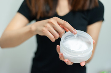 Woman applying moisturizing cream/lotion on hands, beauty concept.