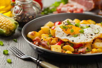 Traditional American hash with fried eggs. Front view.