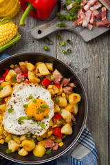 Traditional American hash with fried eggs. Top view.