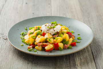 Traditional American hash with fried eggs. Front view.