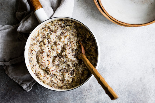 Multigrain porridge in a saucepan with wooden spoon