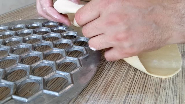 Cellular form for making dumplings.	Dough on cellular form for making dumplings in domestic kitchen	