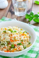 Italian risotto with vegetables - peas, beans, carrots, peppers on a white plate, selective focus