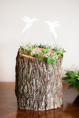 Tree trunk with floral wedding decoration on it
