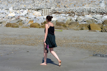 Jeune femme brune marchant sur la sable