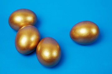 Golden eggs on a blue surface