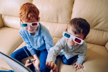 Cheerful siblings reading a book together with 3d glasses. Educational books and learning activities for intellectually active children sharing leisure activities at home. Family lifestyle.