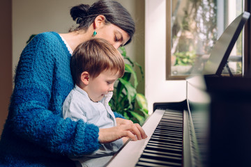 Family lifestyle spending time together indoors. Children with musical virtue and artistic...
