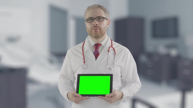 Concerned doctor holds modern tablet PC with green screen, shot on Red camera. Alpha matte for easy picture or video placement