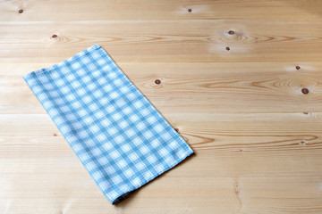 Background with checkered blue napkin on a wooden table. Copy space.