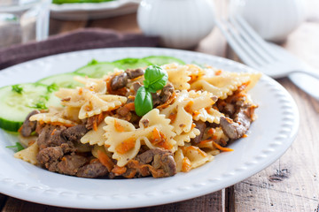 Farfalle with fried chicken liver and carrots, selective focus