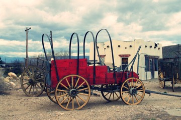 Old fashion horse drawn wood Stage Coach or covered wagon in desert lot on display.  i