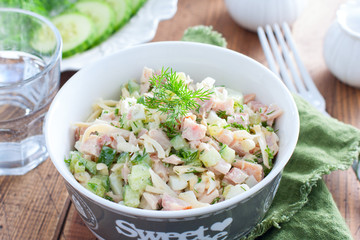 Smoked chicken salad with fresh cucumber in a white bowl, selective focus