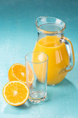 Jug with orange juice on a blue background