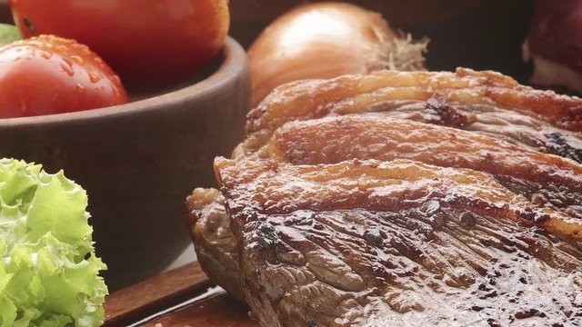 Bifes de churrasco em t&aacute;bua de madeira com acompanhamentos