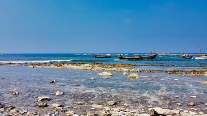 Fototapeta premium NGWE SAUNG/MYANMAR - MARCH 14, 2020 : Burmese fishermen bear caught fish in baskets on the beach Ngwe Saung Myanmar