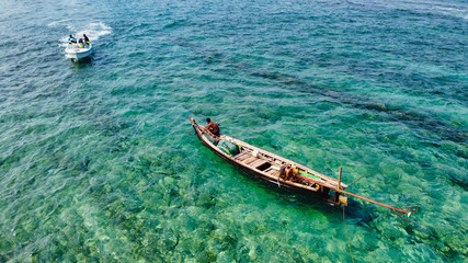 Fototapeta premium NGWE SAUNG/MYANMAR - MARCH 14, 2020 : Burmese fishermen bear caught fish in baskets on the beach Ngwe Saung Myanmar