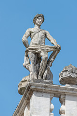 Old roof statue of a Renaissance Era naked Roman philosopher and poet in Leipzig downtown, Germany,...