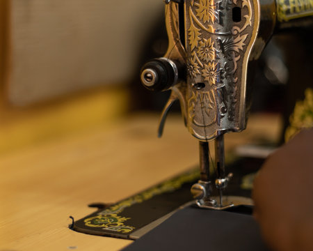 Close Up View Of Sewing Machine With Intricate Designs In Silver Decorative Plate. African Woman In Kenya Sewing.