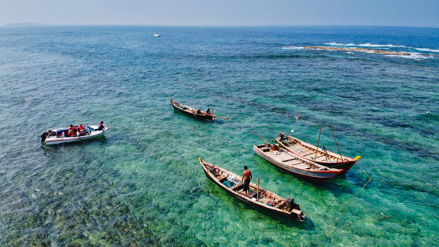 NGWE SAUNG/MYANMAR - MARCH 14, 2020 : Burmese fishermen bear caught fish in baskets on the beach Ngwe Saung Myanmar
