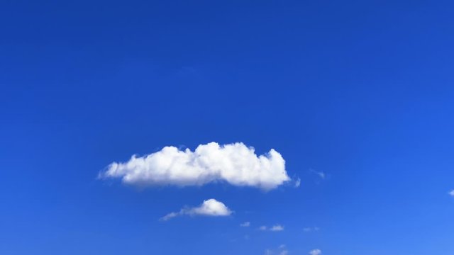 青空にぽっかり浮かぶ真っ白な綿雲 高度を下げながら通過する飛行機