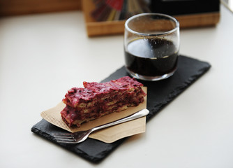 Served black coffee and dessert. Slate board, vegan cake Napoleon Millefeuille on a paper coffee filter
